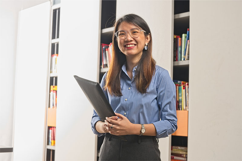 Woman smiling with a laptop sleeve in hand