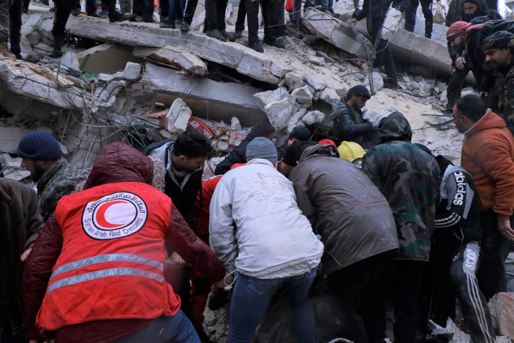 a group of people moving a pile of rubble