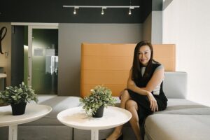 Ms Trina Liang-Lin on a couch posing for a photo