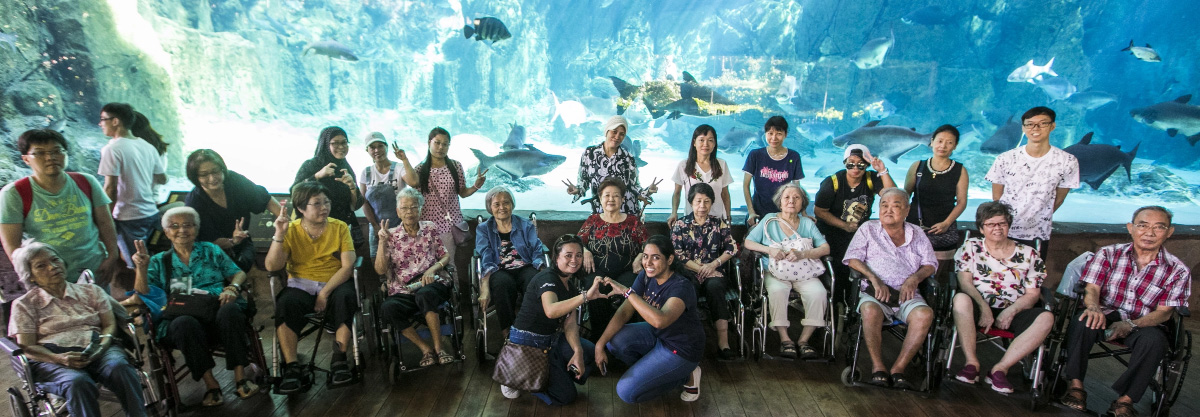 A bunch of people posing infront of an aquarium