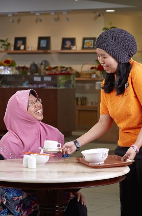 A lady serving coffee to another lady