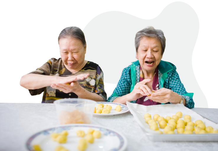 Two elderly people rolling dessert balls