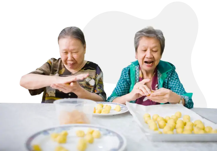 Two elderly people rolling dessert balls