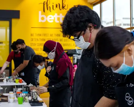 A few people with masks making drinks