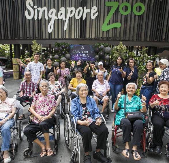 A group of people posing for a photo in front of Singapore Zoo