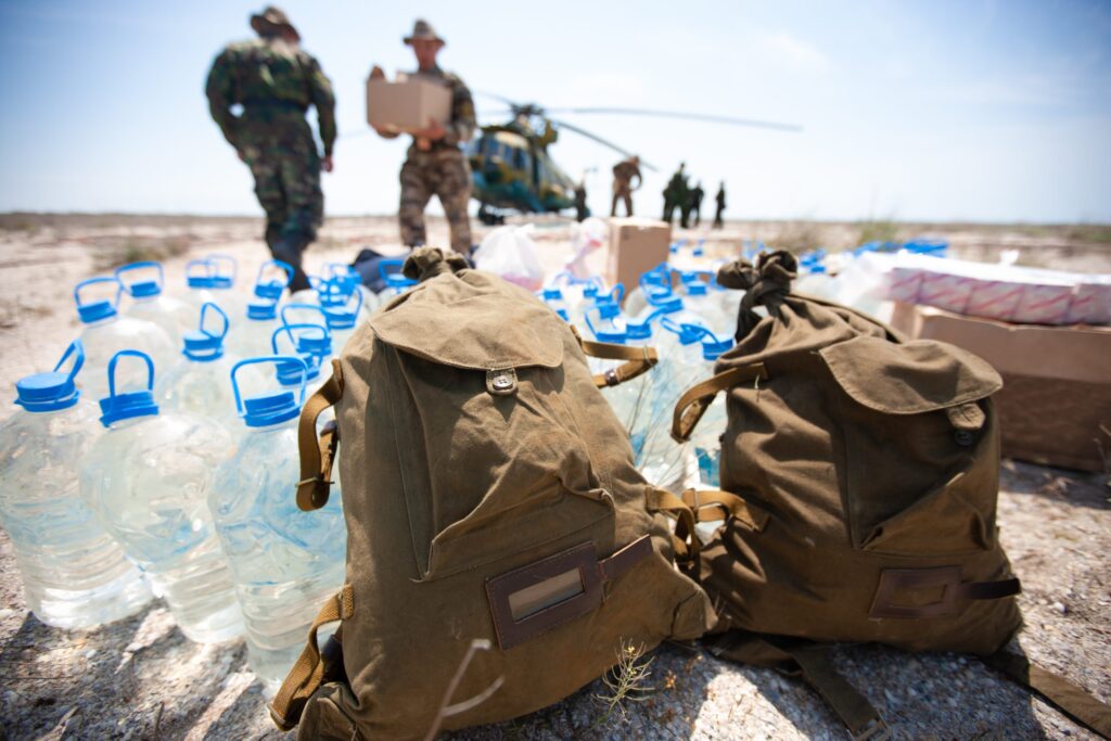a group of military men transporting boxes of water using a helicopter