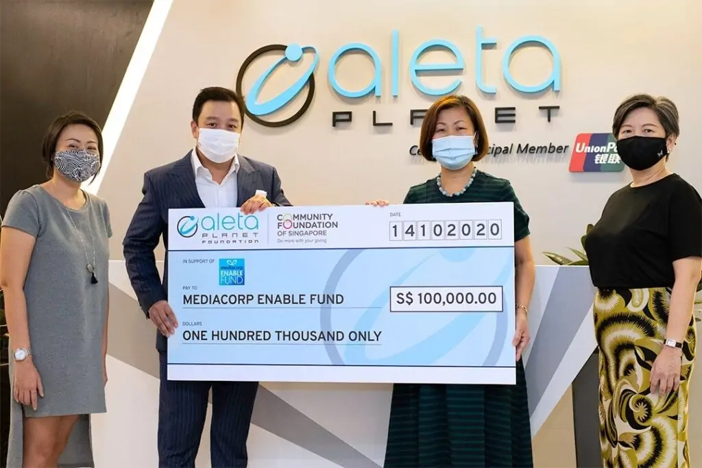 Three people posing with a check from Aleta Planet, expressing joy.