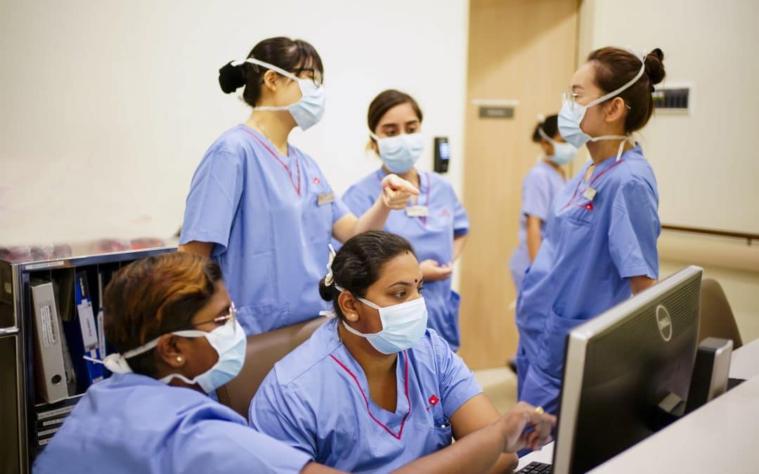 Healthcare professionals in scrubs engaged in a variety of tasks.