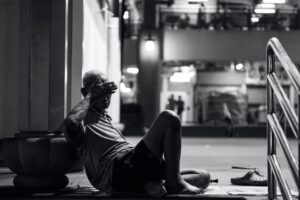 a homeless person sitting on the ground