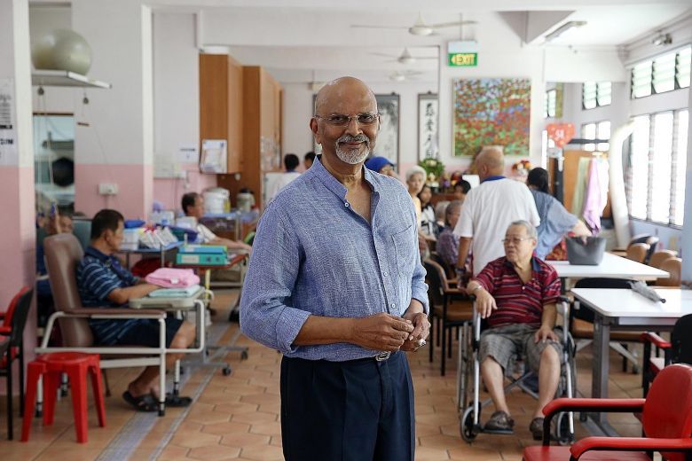 Mr Govind Bommi posing infront of the camera advocating for giving back to the community with elderly people in the back