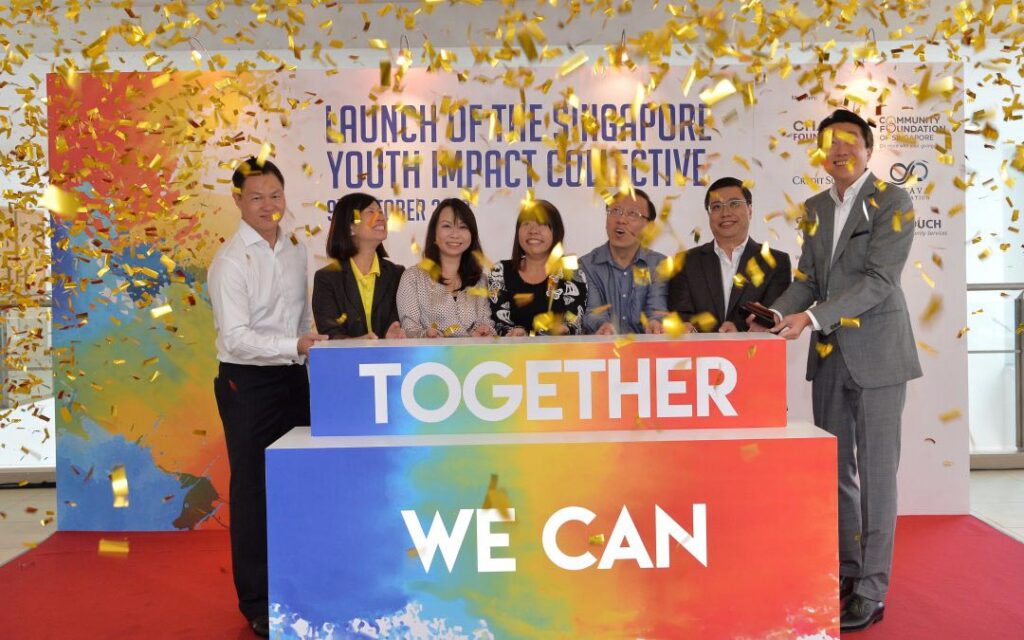 A diverse group of individuals standing united in front of a sign displaying the empowering message "Together We Can.". (From left) James Tan, Tan-Wu Mei Ling, Justina Tan, Joyce Teo, Dr Ang Kiam Wee, Pang Sze Khai and Jacky Ang.