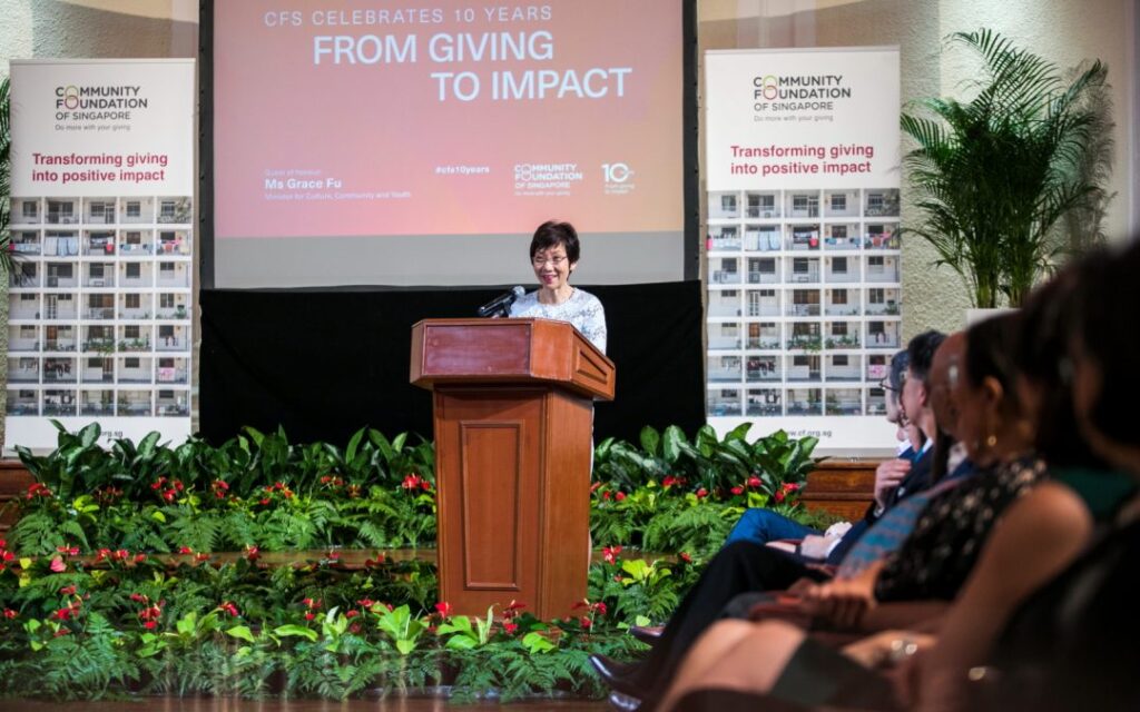 Grace Fu delivering speech at podium to audience.