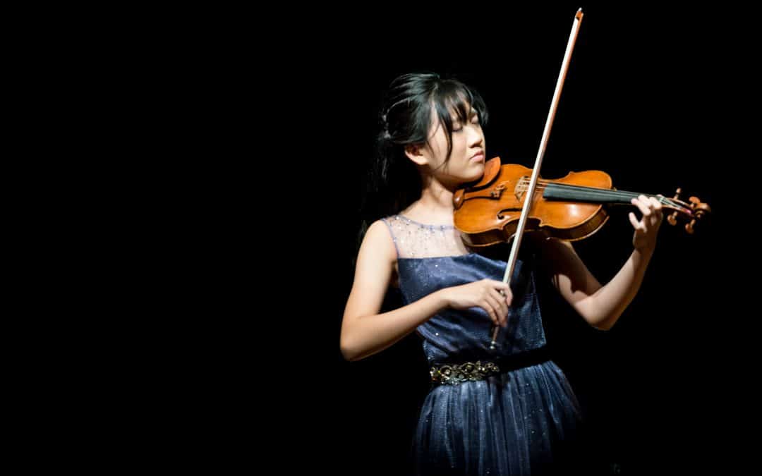 a picture of a girl playing a violin