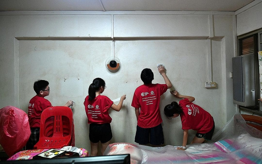 four teenagers helping to clean a dirty wall