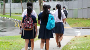 School children walking on the pavement.