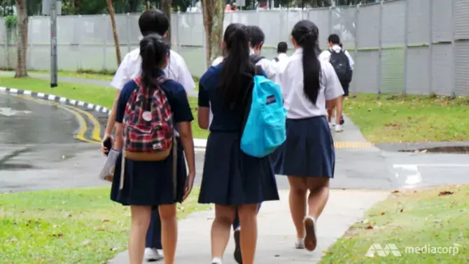 School children walking on the pavement.